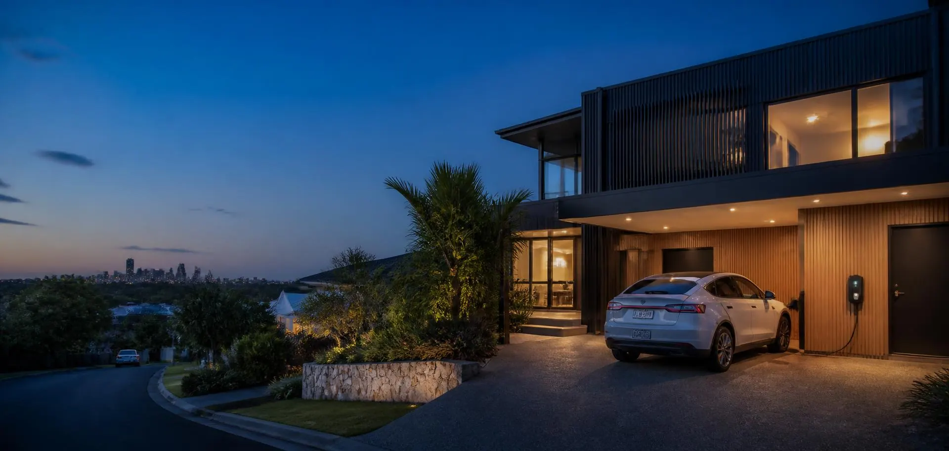 Electric car charging in the driveway of a contemporary Gold Coast home at dusk